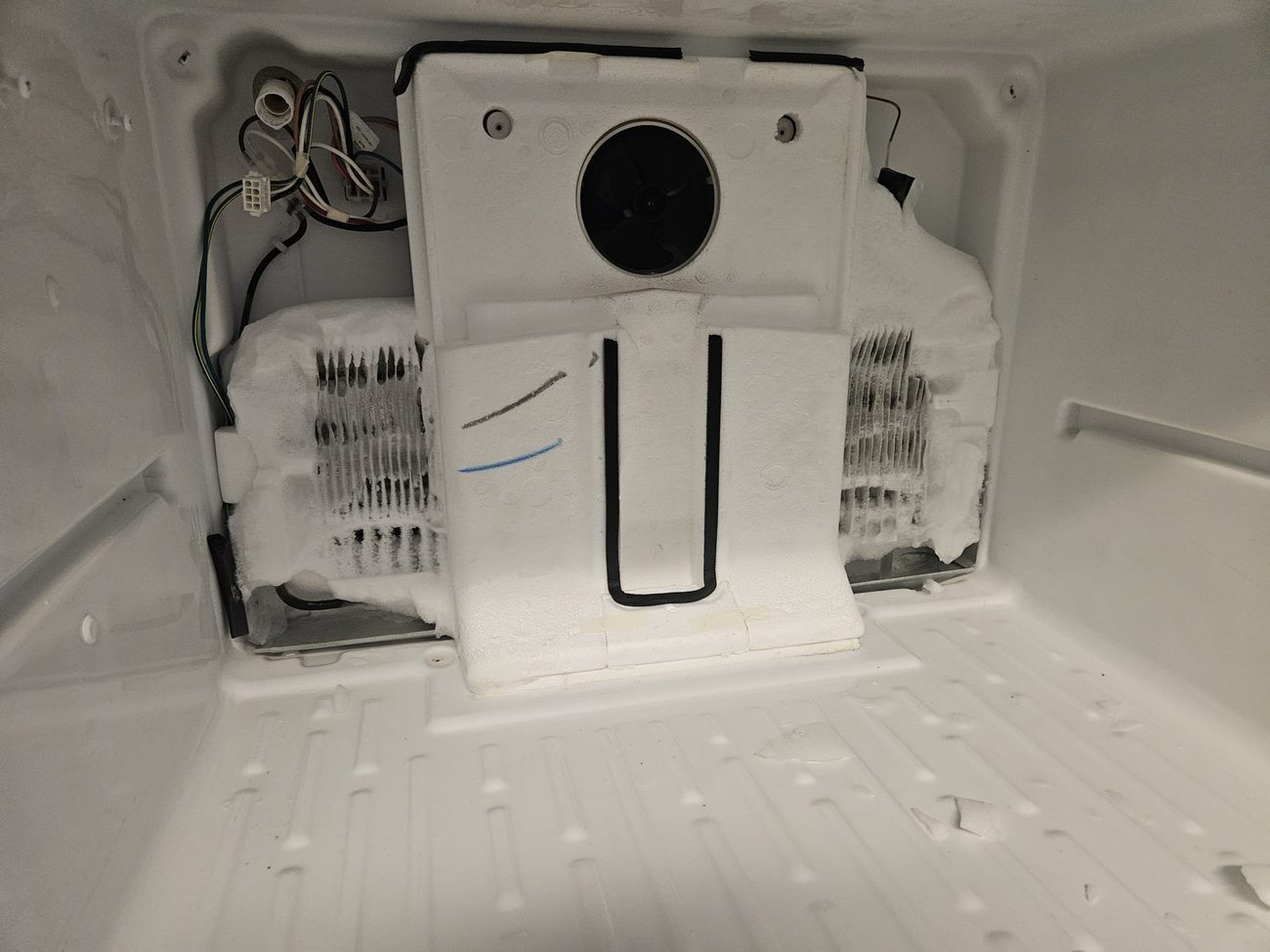 Freezer evaporator fan and frosted cooling coils exposed during repair by Caspian Appliance Repair in Hamilton, Ontario