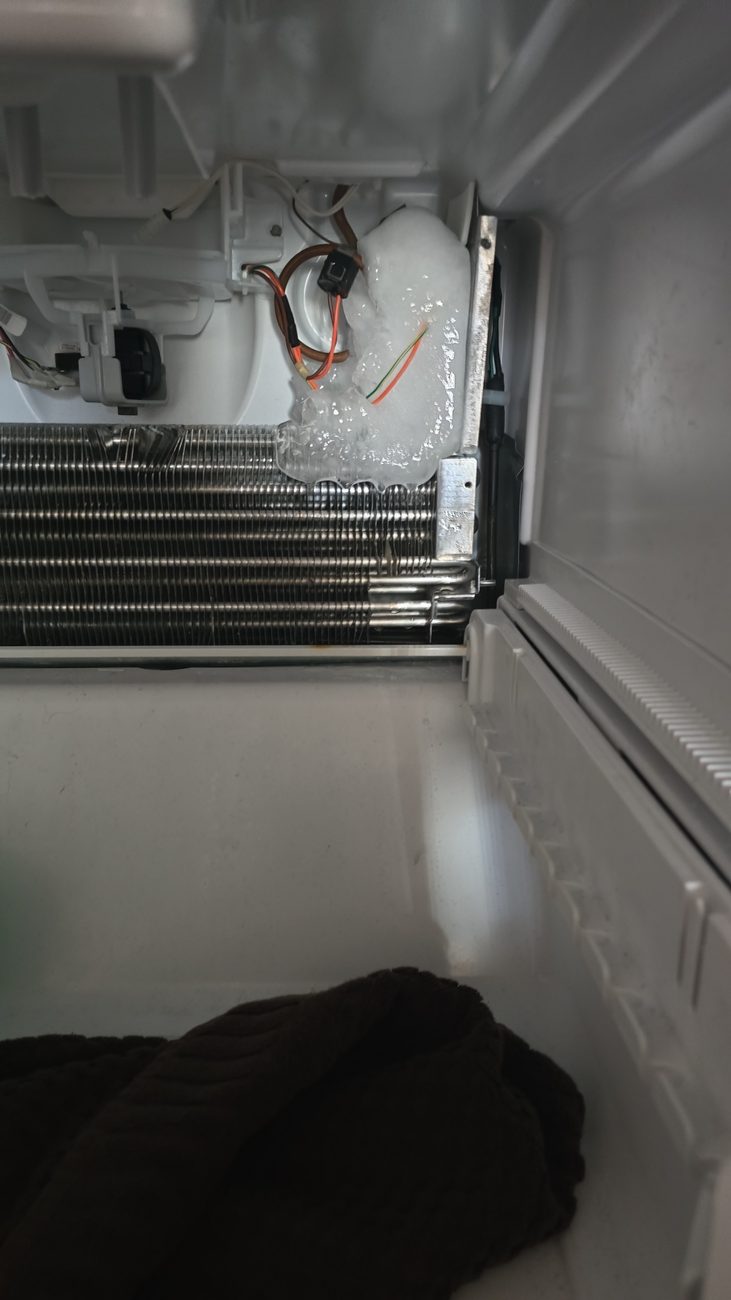 Ice build-up around a freezer evaporator and drain area during a defrost repair by Caspian Appliance Repair in Hamilton, Ontario