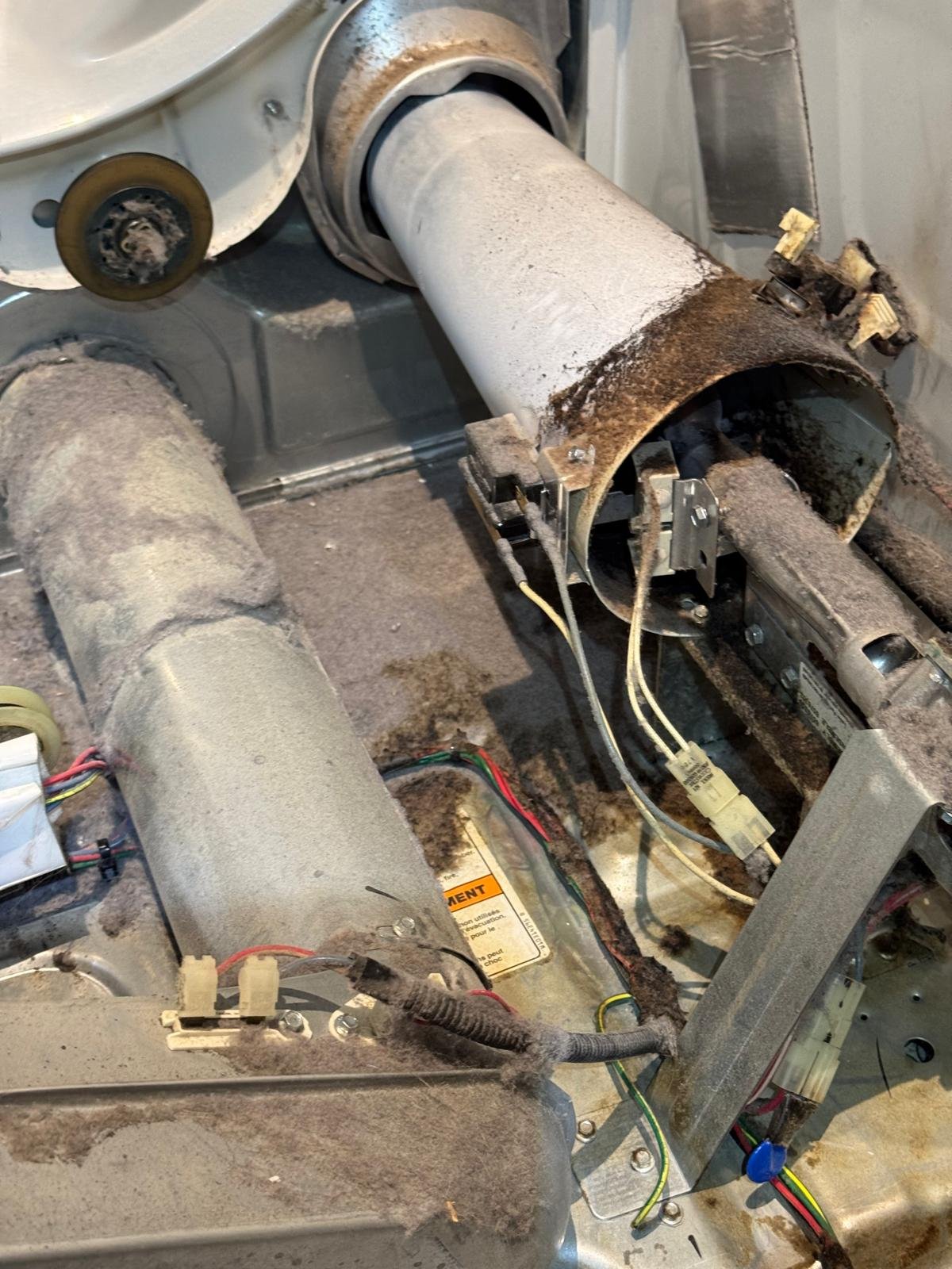 Frigidaire gas dryer burner assembly with igniter being replaced by a TSSA-licensed partner technician for Caspian Appliance Repair in Hamilton, Ontario