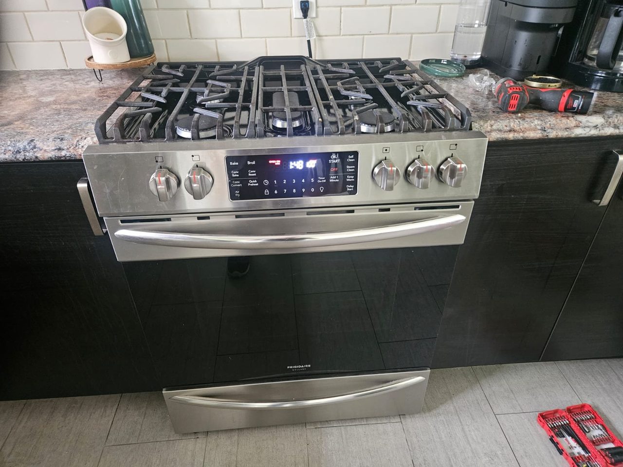 Frigidaire Gallery gas range with five-burner cooktop, control panel powered on for testing during a repair by Caspian Appliance Repair in Hamilton, Ontario