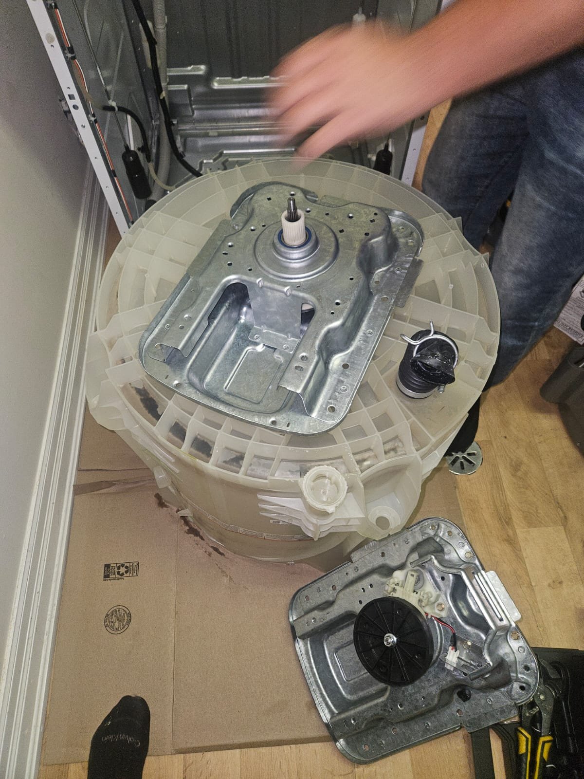 GE combination washer and dryer with outer tub removed showing transmission and drive system during transmission replacement by Caspian Hamilton technician