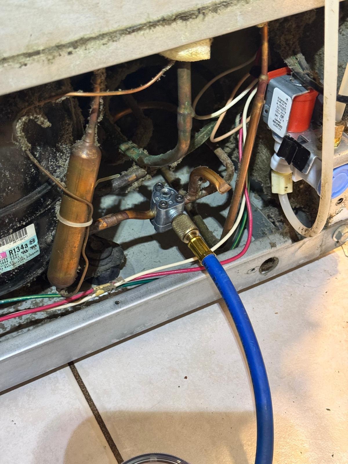 Close-up of R134a refrigerant line recharge on refrigerator compressor by Caspian Appliance Repair Hamilton