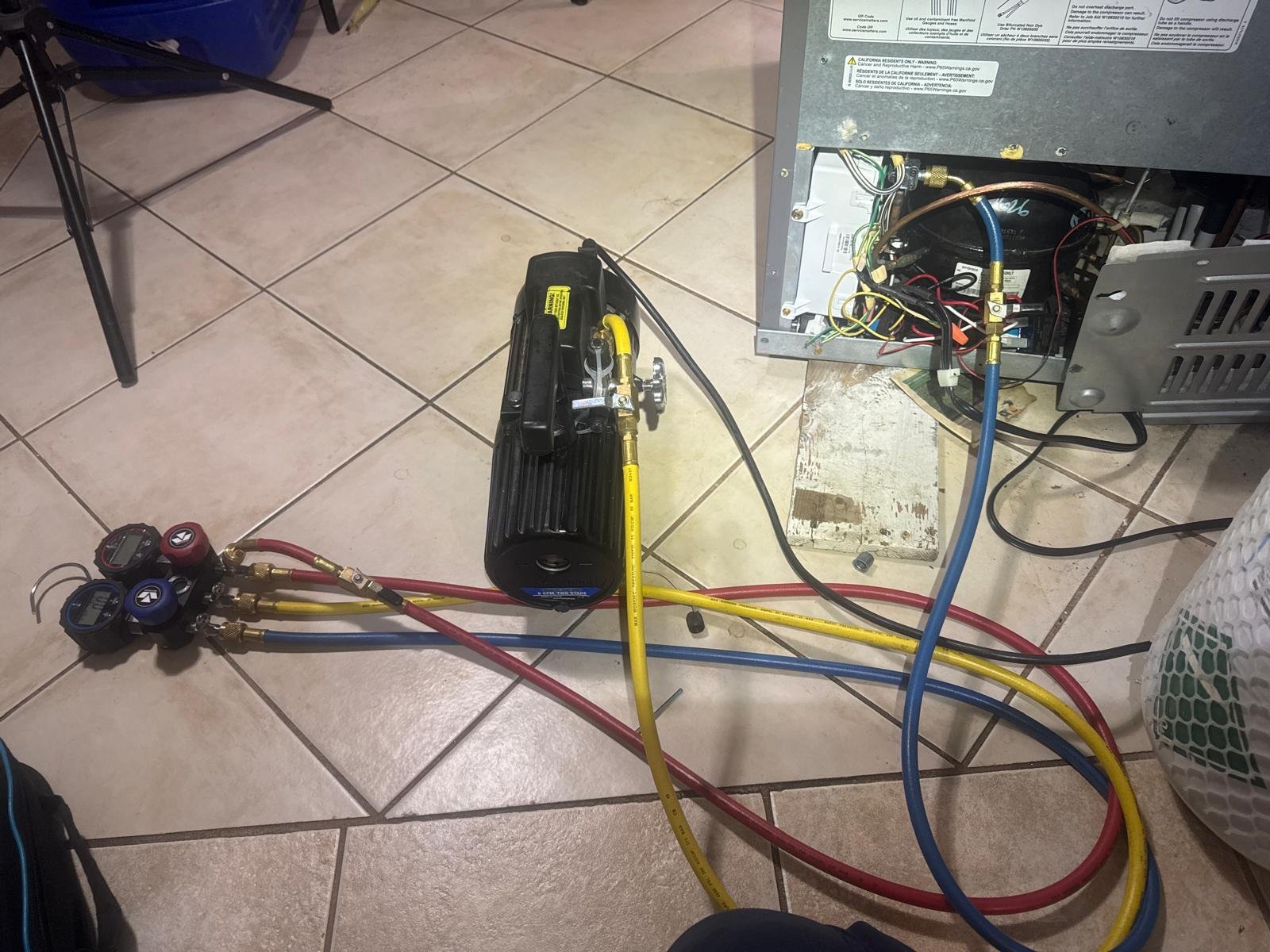 Caspian technician performing refrigerator sealed-system service with professional vacuum pump and manifold gauges in Hamilton, Ontario