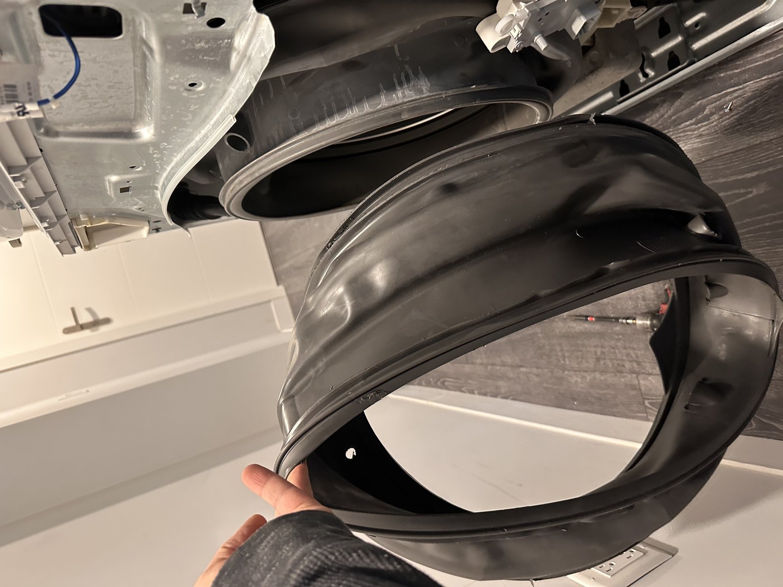 Worn front-load washer door seal boot being removed during gasket replacement by Caspian Appliance Repair Hamilton technician