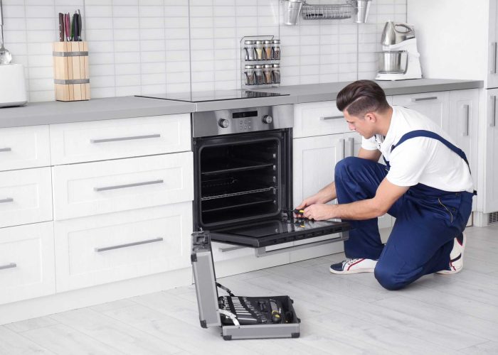 homeguide-oven-repair-technician-fixing-an-oven